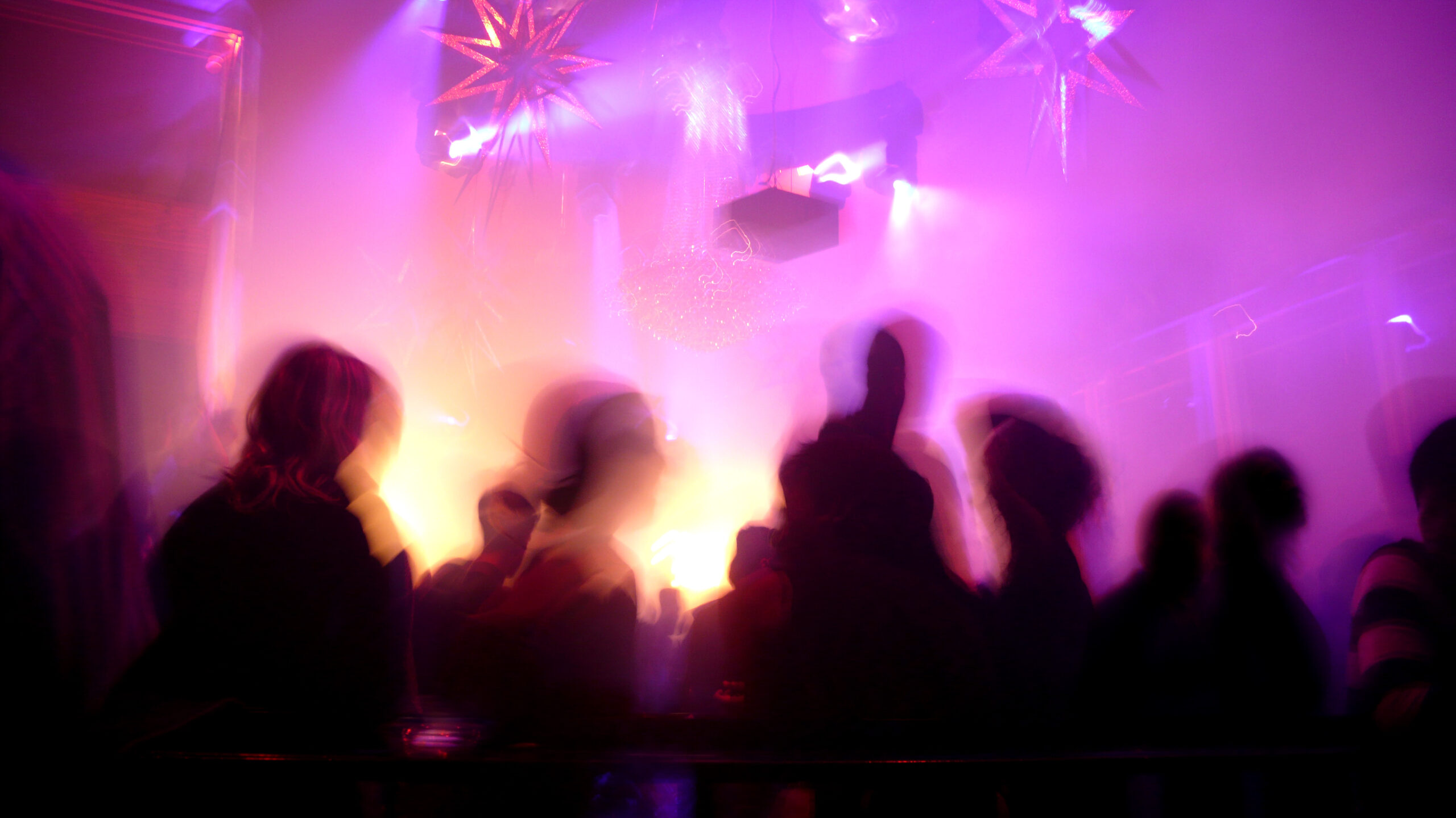 Nightclub scene with dance floor crowd in motion